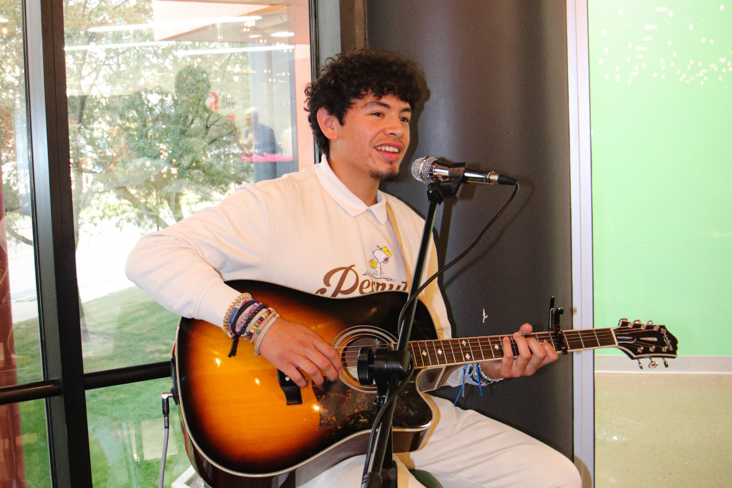 Josue Barahona smiles while playing the guitar
