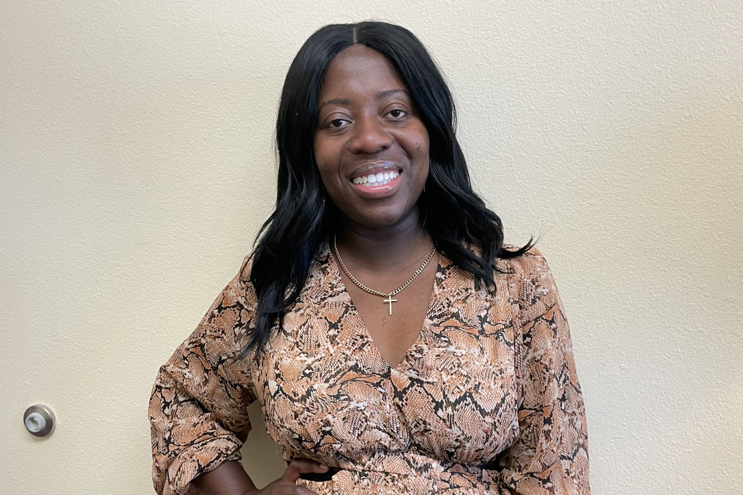 Matthea Little Smith stands in front of a sign for Silver Oaks Senior Living